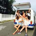 photo of five women sitting in back of van